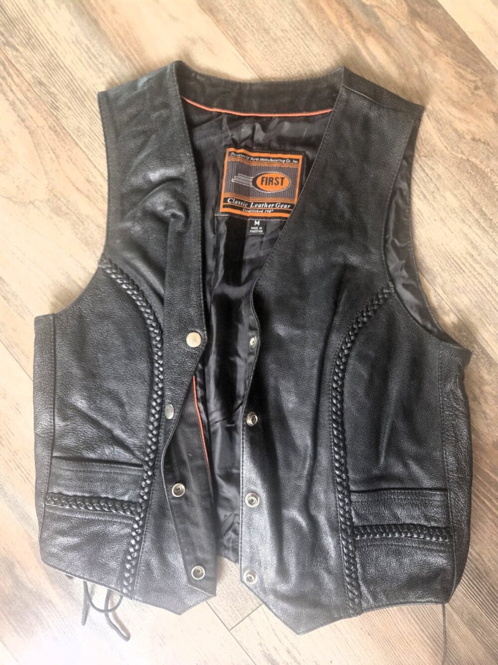 Women’s medium leather vest in soft black cowhide with decorative braided trim